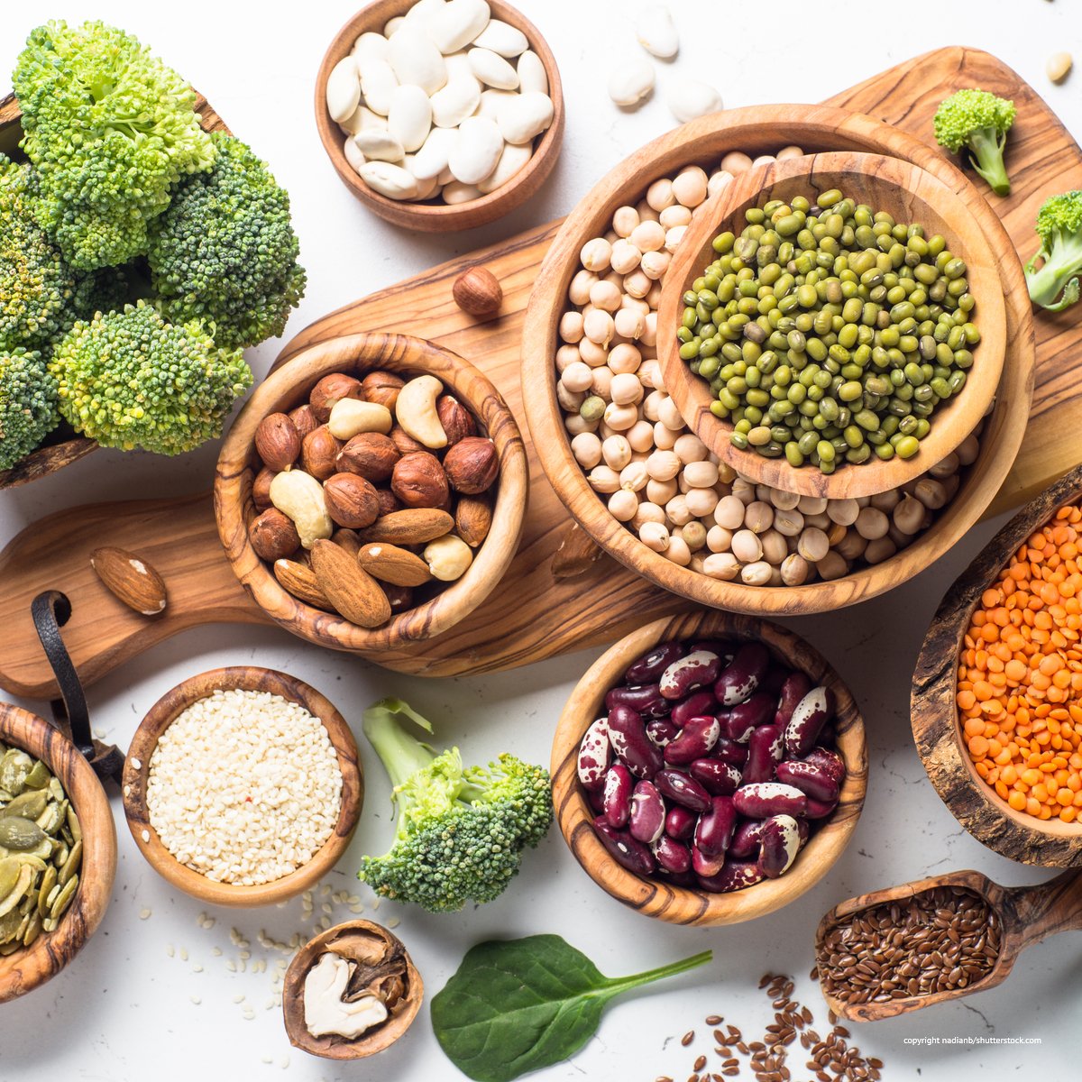 Hülsenfrüchte, Nüsse und Samen auf einem Küchenbrettchen dekoriert. Veganen Lebensmittel fehlt Vitamin B12.