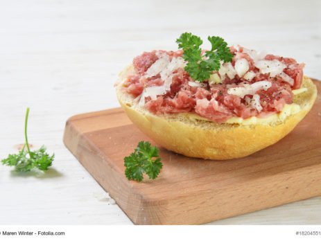 Brötchen mit Mett, Zwiebeln und Petersilie. Mett ist ein Lebensmittel mit Vitamin B12.