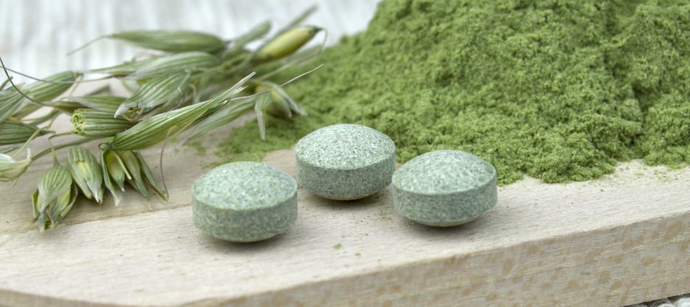 Chlorella Algen auf einem Brettchen: frisch, getrocknet und Tabletten. Die Algen liefern vitaminwirksames B12, keine B12-Analoga wie viele andere Algenarten.