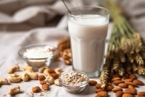 Frische veganische Alternativmilch in großem Glas. Gesunde vegetarische Küche Konzept. Mandeln, Cachou, Walnuss, Hafermehl, Kokosnuss