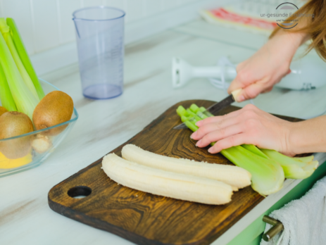 Vitamin B12 und vegane Ernährung. Der Stellenwert von Vitamin B12. Eine Veganerin bereitet einen Smoothie aus Bananen, Kiwi und Sellerie zu.