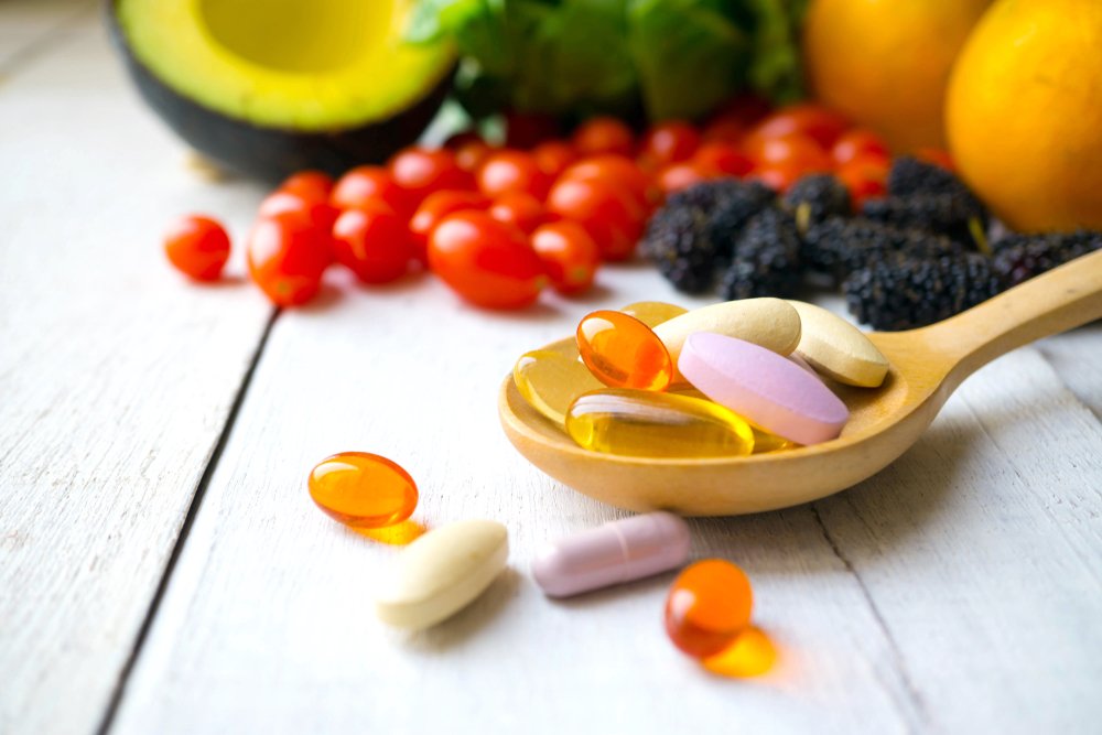 Vitamin B12 und vegane Ernährung. Nahrungsergänzung. Pillen und Kapseln auf einem Holzlöffel.